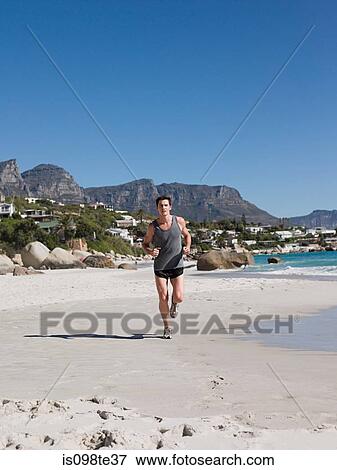Young man jogging on beach View Large Photo Image Stock Photo - Young man jogging on beach. Fotosearch