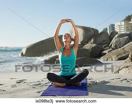 Young woman doing yoga on beach View Large Photo Image Stock Image - Young woman doing yoga on beach. Fotosearch