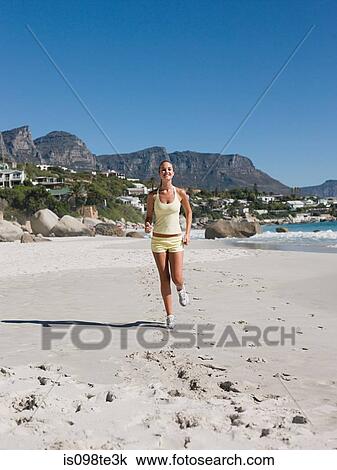 Young woman jogging on beach View Large Photo Image Stock Image - Young woman jogging on beach. Fotosearch