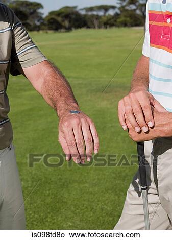 Two mature men playing golf together, tossing a coin View Large Photo Image Picture - Two mature men playing golf together, tossing a coin. Fotosearch