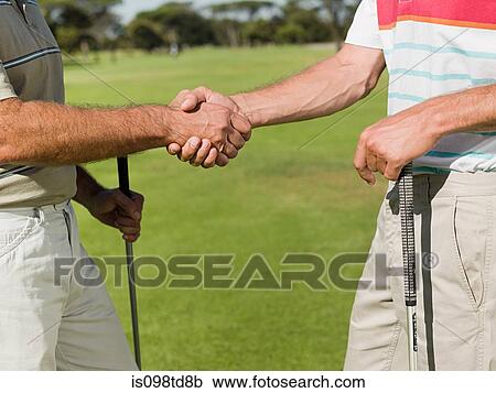 Two mature men shaking hands on golf course View Large Photo Image Stock Image - Two mature men shaking hands on golf course. Fotosearch