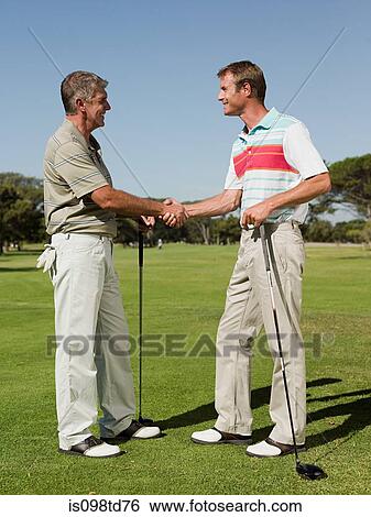 Two mature men shaking hands on golf course View Large Photo Image Stock Photograph - Two mature men shaking hands on golf course. Fotosearch