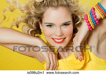 Young blonde woman against yellow background View Large Photo Image Stock Image - Young blonde woman against yellow background. Fotosearch