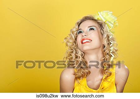 Young blonde woman against yellow background View Large Photo Image Stock Photo - Young blonde woman against yellow background. Fotosearch