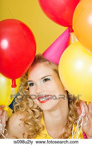 Young blonde woman with balloons against yellow background View Large Photo Image Stock Photo - Young blonde woman with balloons against yellow background. Fotosearch