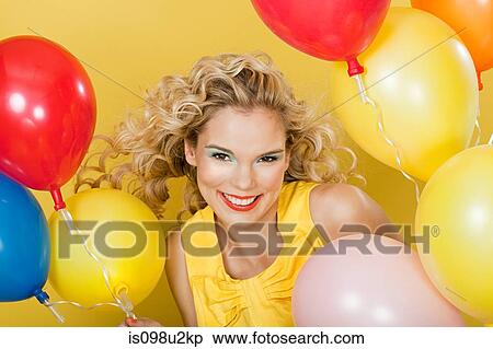 Young blonde woman with balloons against yellow background View Large Photo Image Stock Photography - Young blonde woman with balloons against yellow background. Fotosearch
