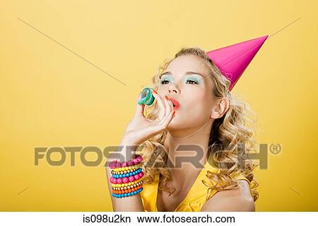 Picture - Young woman wearing party hat with party streamer. Fotosearch