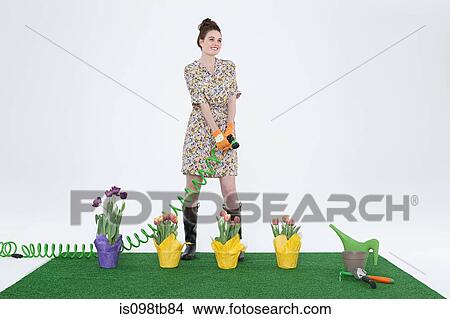 Woman with hose and flowers on artificial turf View Large Photo Image Picture - Woman with hose and flowers on artificial turf. Fotosearch