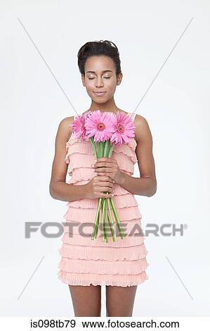 Young woman closing eyes and holding flowers View Large Photo Image Stock Photo - Young woman closing eyes and holding flowers. Fotosearch