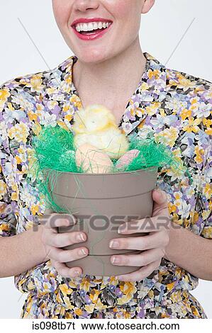 Young woman with easter chick and eggs in flower pot View Large Photo Image Stock Photograph - Young woman with easter chick and eggs in flower pot. Fotosearch