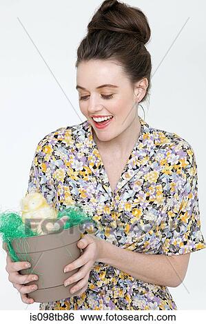 Young woman with easter chick and eggs in flower pot View Large Photo Image Stock Photograph - Young woman with easter chick and eggs in flower pot. Fotosearch