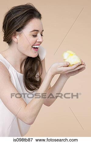 Stock Photo - Young woman with easter chick. Fotosearch
