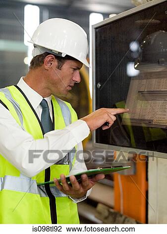 Mature man inspecting factory equipment View Large Photo Image Stock Image - Mature man inspecting factory equipment. Fotosearch