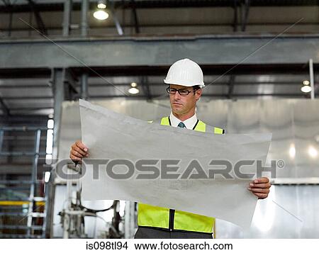 Mature man with blueprint in factory View Large Photo Image Picture - Mature man with blueprint in factory. Fotosearch