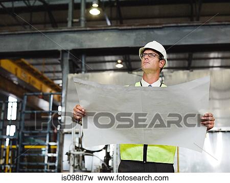 Mature man with blueprint in factory View Large Photo Image Stock Photo - Mature man with blueprint in factory. Fotosearch