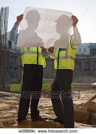 Mature men inspecting blueprints on construction site View Large Photo Image Stock Image - Mature men inspecting blueprints on construction site. Fotosearch