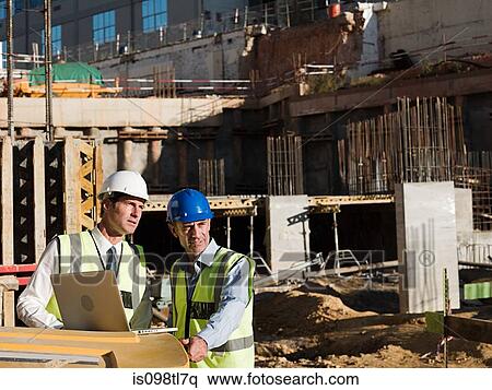 Mature men using laptop on construction site View Large Photo Image Stock Photography - Mature men using laptop on construction site. Fotosearch