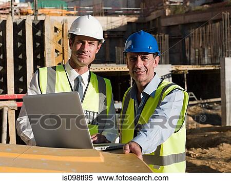 Mature men uusing laptop on construction site View Large Photo Image Stock Photography - Mature men uusing laptop on construction site. Fotosearch