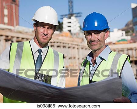 Mature men with blueprint on construction site View Large Photo Image Stock Photograph - Mature men with blueprint on construction site. Fotosearch