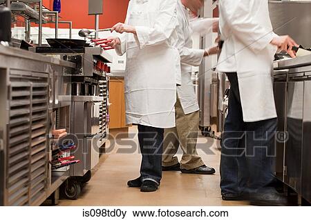 Stock Photo - Chefs preparing food in commercial kitchen. Fotosearch