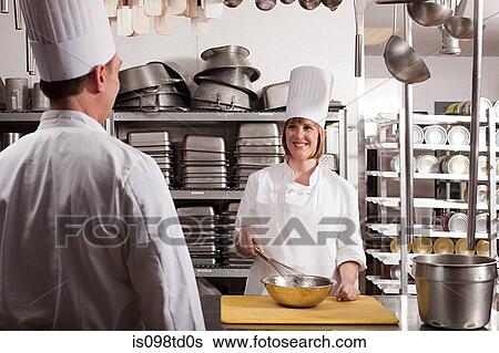 Stock Photograph - Chefs preparing food in commercial kitchen. Fotosearch