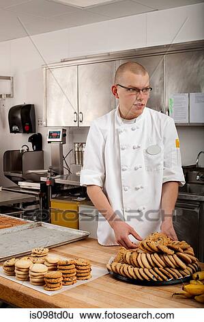 Male chef baking cookies in commercial kitchen View Large Photo Image Stock Photograph - Male chef baking cookies in commercial kitchen. Fotosearch