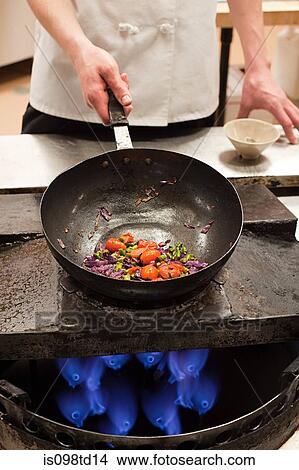 Male chef frying with wok in commercial kitchen View Large Photo Image Picture - Male chef frying with wok in commercial kitchen. Fotosearch