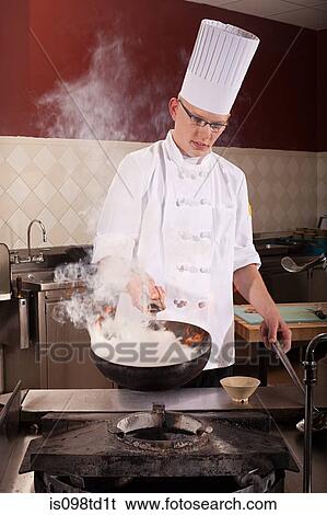 Male chef frying with wok in commercial kitchen View Large Photo Image Stock Photograph - Male chef frying with wok in commercial kitchen. Fotosearch