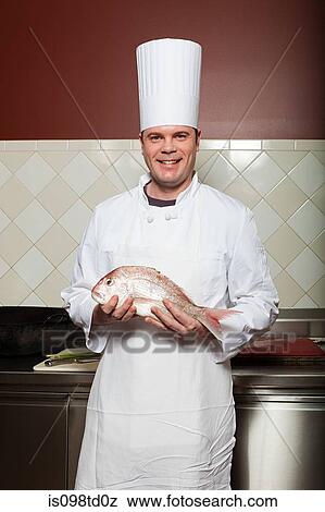 Male chef holding fish in commercial kitchen View Large Photo Image Stock Photo - Male chef holding fish in commercial kitchen. Fotosearch