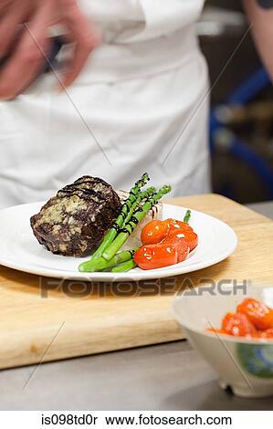 Stock Photography - Male chef preparing meal in commercial kitchen. Fotosearch