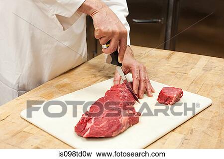 Male chef preparing meat in commercial kitchen View Large Photo Image Stock Photo - Male chef preparing meat in commercial kitchen. Fotosearch