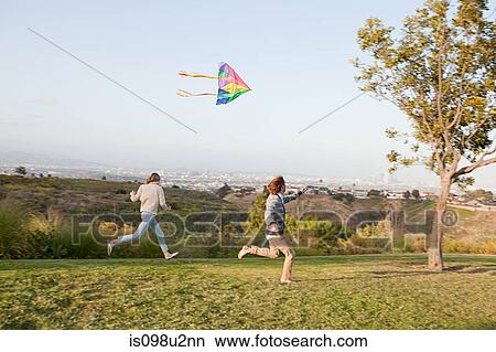 Young couple flying a kite View Large Photo Image Picture - Young couple flying a kite. Fotosearch