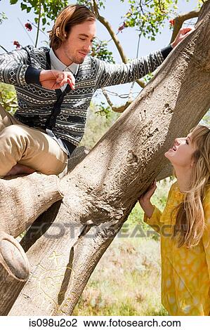 Young couple in a tree View Large Photo Image Stock Image - Young couple in a tree. Fotosearch