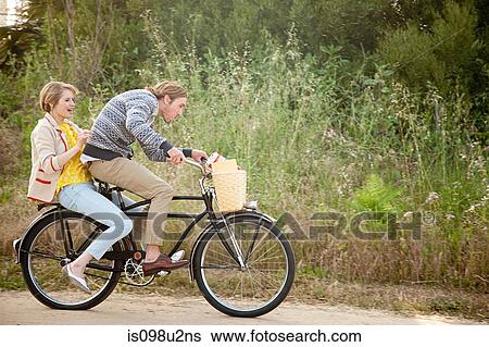 Stock Photograph - Young couple on a bicycle. Fotosearch
