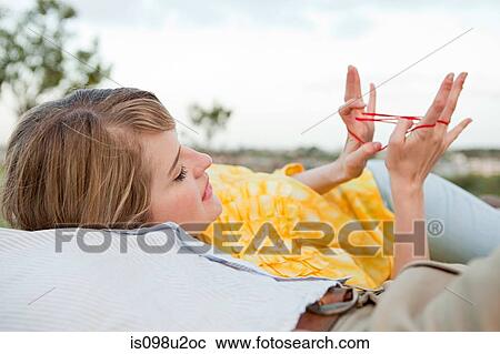 Young couple outdoors, woman playing with string View Large Photo Image Stock Image - Young couple outdoors, woman playing with string. Fotosearch