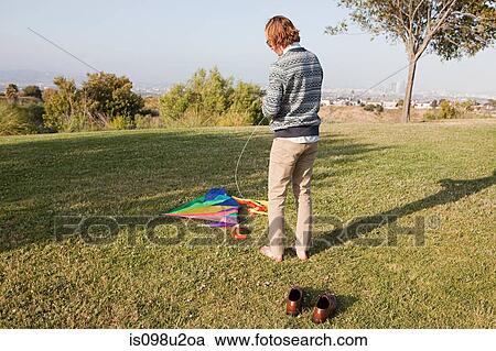 Young man in field with kite View Large Photo Image Stock Image - Young man in field with kite. Fotosearch