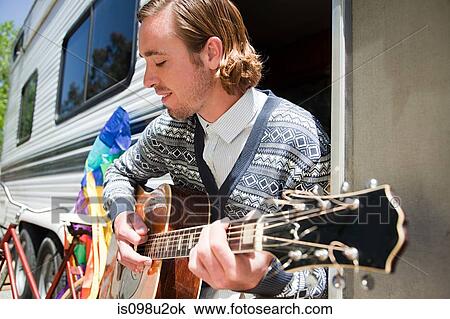 Young man playing guitar View Large Photo Image Stock Image - Young man playing guitar. Fotosearch