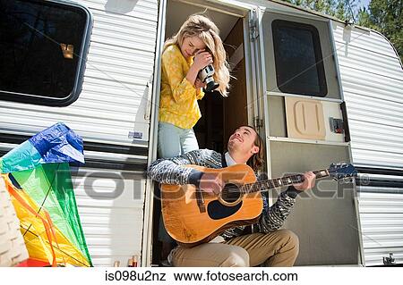 Young woman filming boyfriend playing the guitar View Large Photo Image Stock Photo - Young woman filming boyfriend playing the guitar. Fotosearch