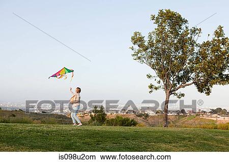 Young woman flying a kite in field View Large Photo Image Picture - Young woman flying a kite in field. Fotosearch