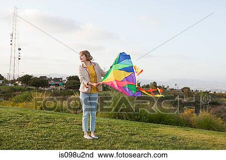 Young woman in a field with a kite View Large Photo Image Stock Image - Young woman in a field with a kite. Fotosearch