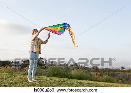 Young woman in a field with a kite View Large Photo Image Stock Image - Young woman in a field with a kite. Fotosearch