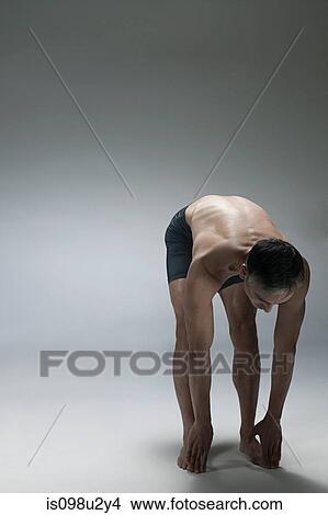 Picture - Mature man bending forward. Fotosearch