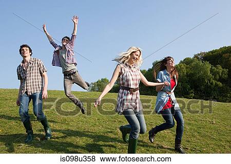 Friends running and jumping outdoors View Large Photo Image Stock Photo - Friends running and jumping outdoors. Fotosearch