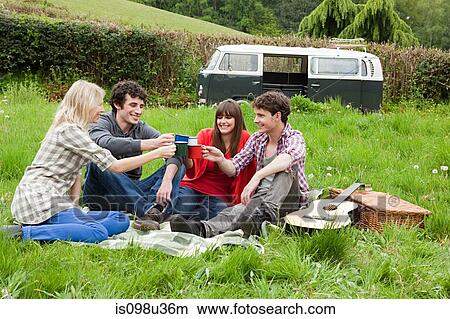 Picture - Friends toasting with mugs outdoors. Fotosearch