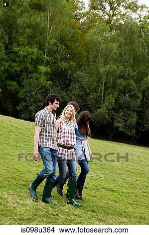 Young adult friends walking down hill View Large Photo Image Picture - Young adult friends walking down hill. Fotosearch