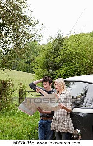 Young couple by camper van looking at map View Large Photo Image Stock Image - Young couple by camper van looking at map. Fotosearch