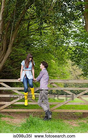 Young couple by gate in countryside View Large Photo Image Stock Image - Young couple by gate in countryside. Fotosearch