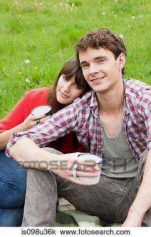 Young couple in field with cups View Large Photo Image Stock Image - Young couple in field with cups. Fotosearch