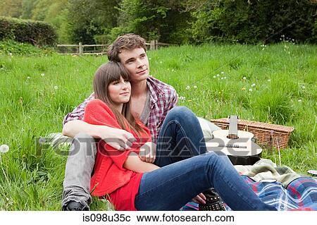 Stock Image - Young couple on blanket in field. Fotosearch