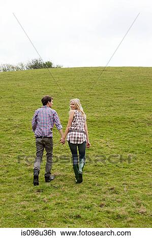 Young couple walking up hill View Large Photo Image Stock Image - Young couple walking up hill. Fotosearch